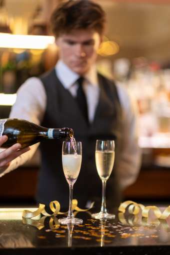 Waiter Pouring Champagne at Bar 